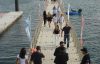 people wearing black on a pier