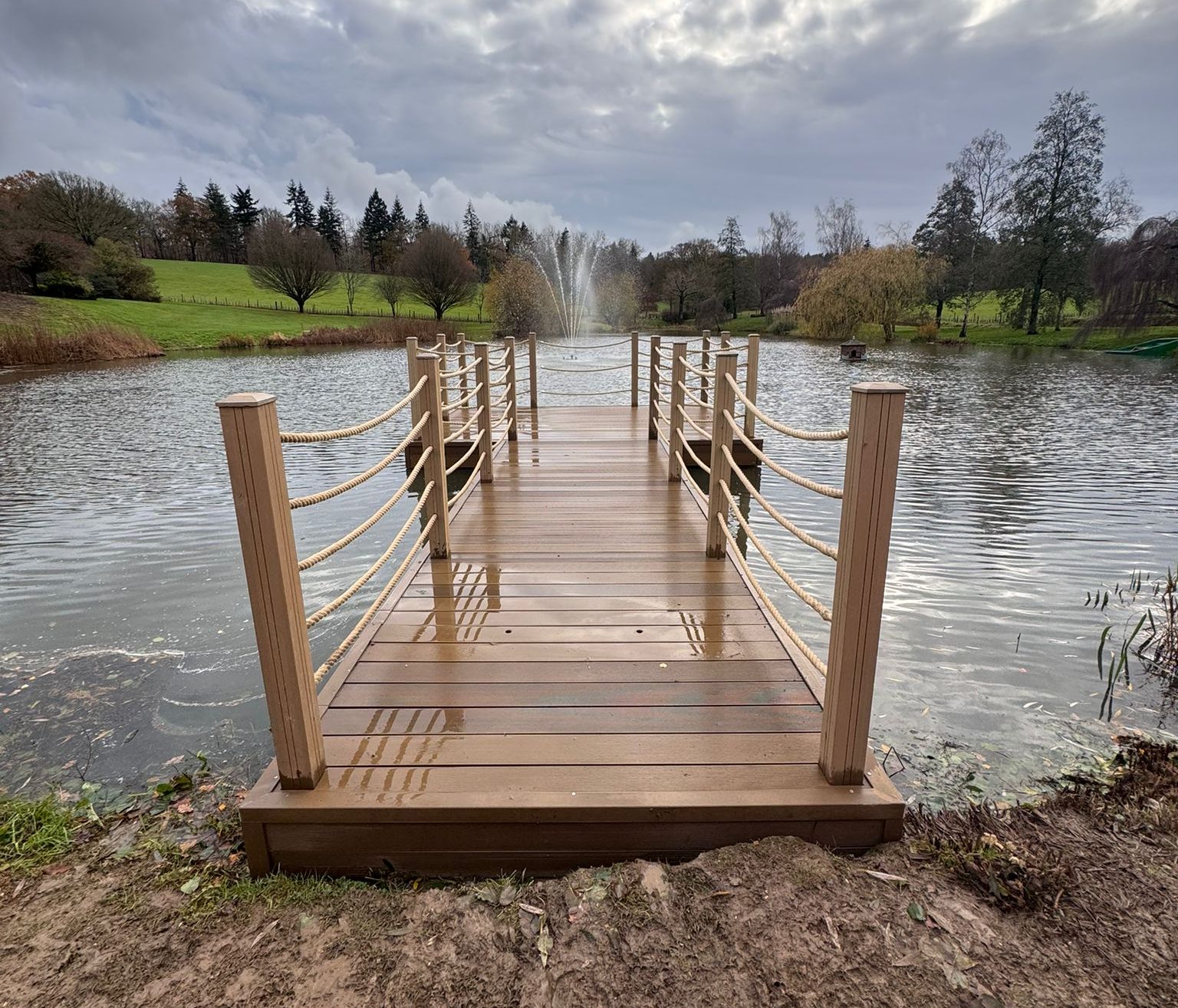 Completed hammerhead jetty with hemp rope handrails and fountain in the distance on the lake